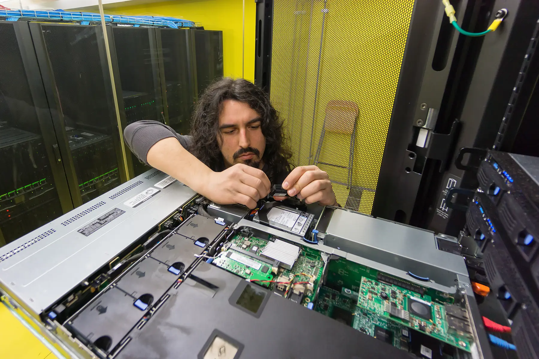 Technician maintaining rack-mounted server hardware at Web Host Pro