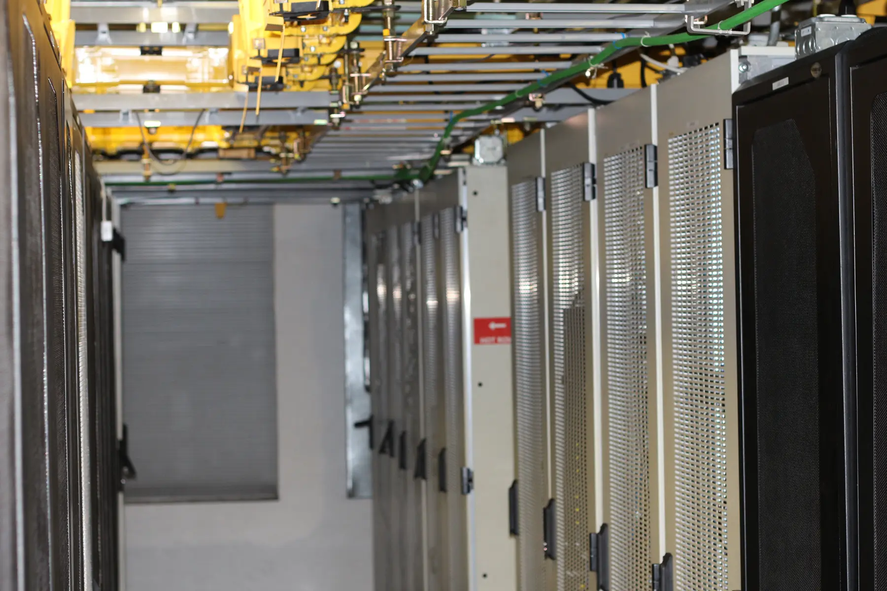 Server cabinet aisle with overhead cable trays in the Los Angeles data center